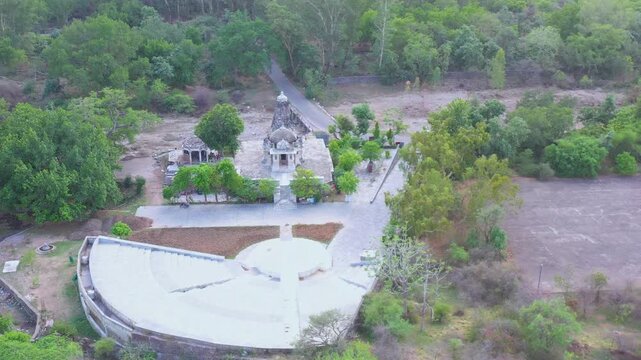 A drone moves closer to the Ranakpur Jain Temple in Rajasthan, capturing its intricate architecture set amid forested hills.