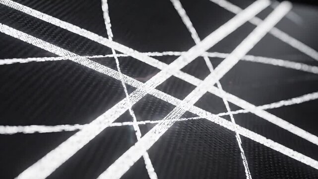 Abstract background featuring intersecting luminous white glowing light streaks on a dark textured carbon fiber surface