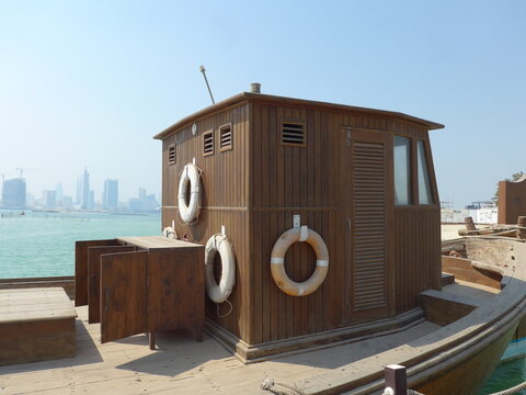 Bahrain, Muharraq - abstract view at Bahrain Pearling Path Museum with dhow in the foreground and skyline in the background