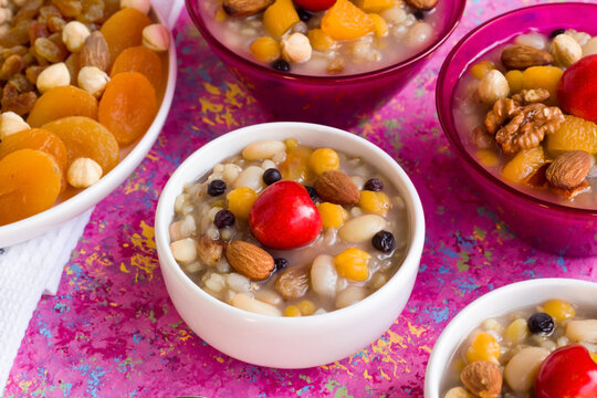 Traditional Turkish dessert Ashure or Noah's Puddings designed on pink surface