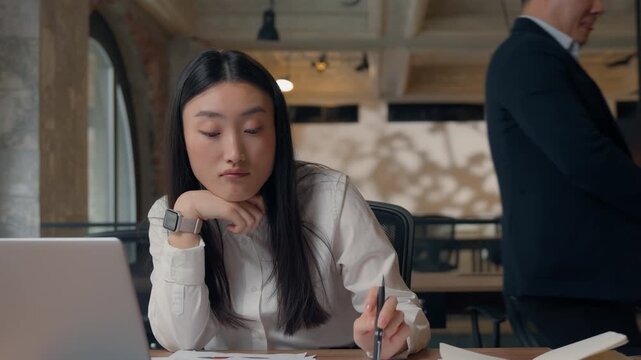 Two Asian business colleagues team problem documents sad intern angry boss in office Korean CEO boss businessman angry scolding unproductive incompetent Japanese Chinese businesswoman job mistake
