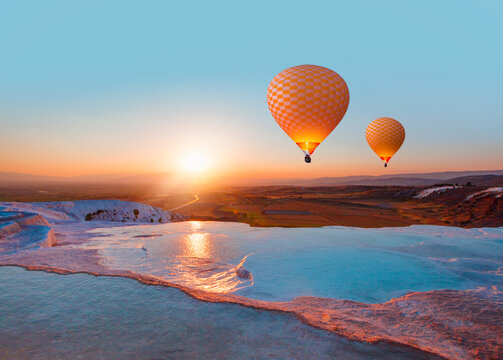 Hot air balloon flying over spectacular pamukkale - Natural travertine pools and terraces in Pamukkale. Cotton castle in southwestern Turkey,