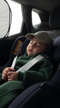 Sleeping baby in car seat with safety harness
