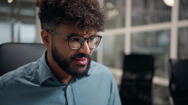 Concentrated smiling Arabian ethnic business man using computer looking at screen desktop monitor smile ethnicity businessman in glasses working enjoy internet virtual technology work male at office