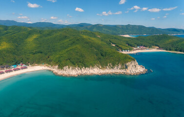 Obraz premium Aerial view shows a tranquil bay with white sand beaches meeting clear turquoise ocean water.