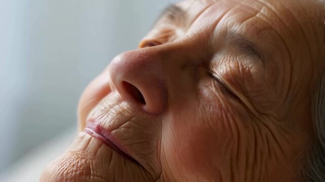 Close-up of a serene elderly woman with closed eyes, embodying peace and contentment in a tranquil setting. A moment of relaxation and inner calm