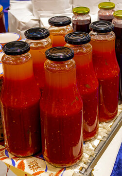 Organic red tomato juices in glass bottles inside home pantry interior