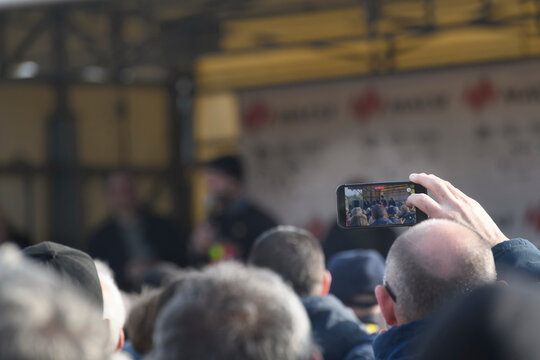 Un spectateur qui filme avec son smartphone