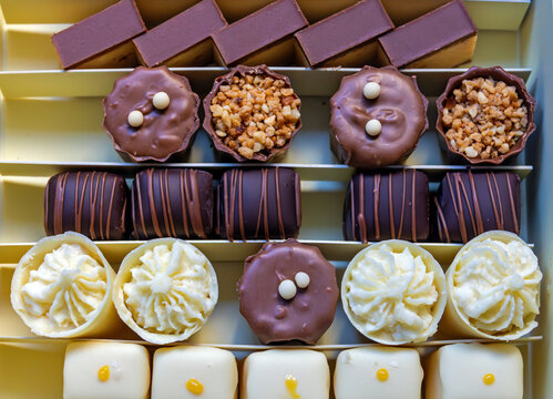 Sweet tasty candy cakes inside chocolate box
