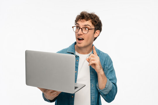 Smiling Caucasian man freelancer IT Programmer hold laptop computer pointing finger up using application, browsing sites, shopping in internet, app, reading website on white studio background