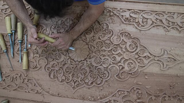 Close-up footage of a skilled artisan carving intricate patterns on wood. Showcasing traditional craftsmanship, fine details, and natural textures in a mesmerizing handmade process.