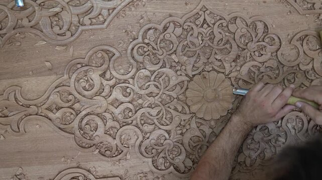 Close-up footage of a skilled artisan carving intricate patterns on wood. Showcasing traditional craftsmanship, fine details, and natural textures in a mesmerizing handmade process.