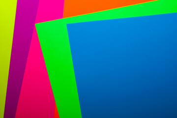 Obraz premium Multicolored sheets of paper are layered on top of each other, creating a bright multi-layered composition with sharp geometric shapes.