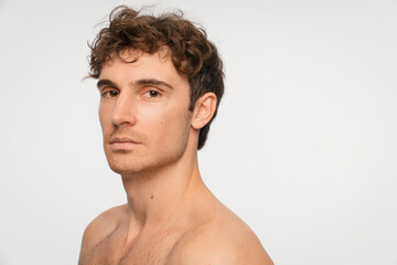 Naklejka premium Beauty, skincare and portrait of man in studio for salon, grooming dermatology. Cosmetics, glow and self care with person and facial on white background for hydration, hygiene and shine, copy space