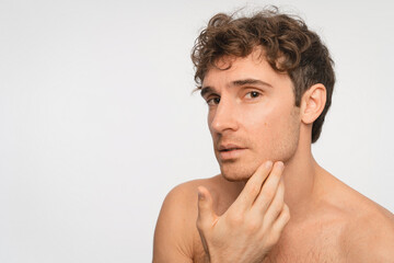 Fototapeta premium Caucasian man, skincare and washing face for grooming, hygiene and hydration in studio. Happy, male person and smile with cleaning or facial treatment for wellness and beauty on white background