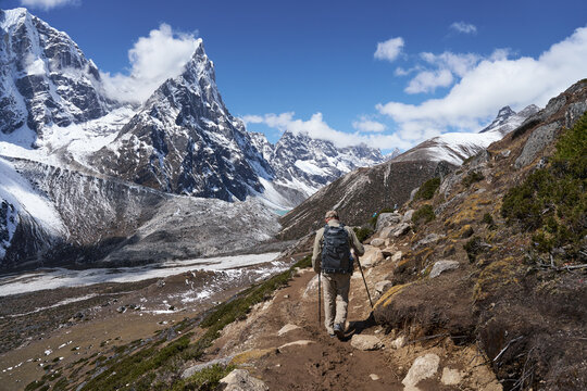 Hiker with backpack of Trekking on Trail Everest Base Camp surrounded by Himalayan Mountains snowy peaks and Glacier. Nepal.
