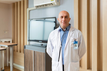 Portrait of caucasian senior doctor in patient wing inside hospital for healthcare and medical