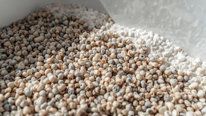 Fototapeta premium Close-up of cat litter granules. Granular toilet filler texture. Box of granulated cat litter with activated carbon. Clean litter in a tray. Background features fresh bentonite.