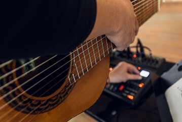 Closeup photo of male guitarist recording and playing guitar Close-up of ten-string nylon guitar played by professional musician