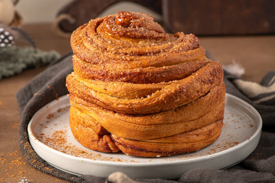 Freshly Baked Cinnamon Roll Cruffin with Sugar Topping on a Ceramic Plate