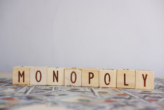 The word MONOPOLY written on scattered dollars. The concept of trade monopoly. Economic control, capitalism, business strategy, or power concentration in modern economics.
