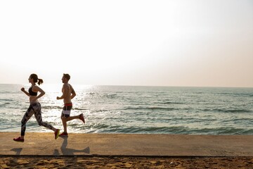 Fototapeta premium Couple jogging along oceanfront photo
