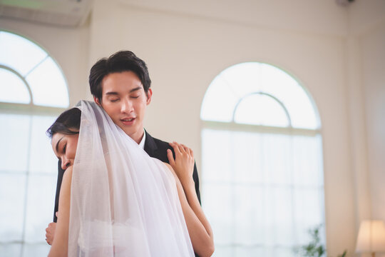 Asian bride and groom hugging with emotional connection during wedding