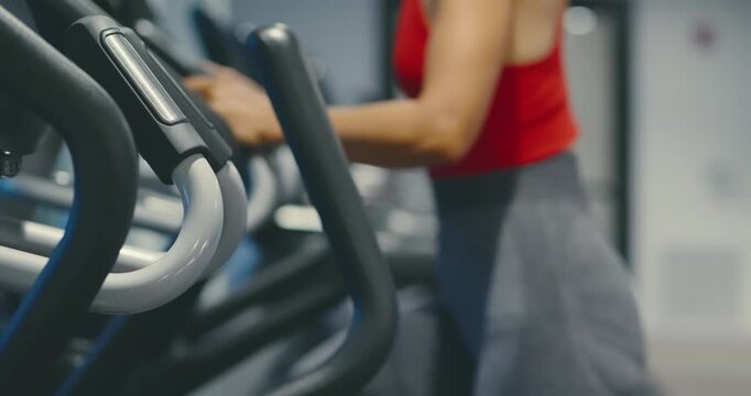 Woman Exercising on Elliptical in Modern Gym
