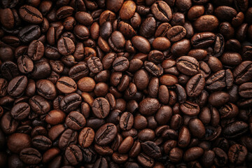 Obraz premium Close-up view of roasted coffee beans showcasing rich textures and varying shades of brown, arranged densely on a dark surface for a natural, organic appearance