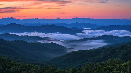 Fototapeta premium Majestic mountain range bathed in vibrant sunrise hues with rolling fog filling the valleys below
