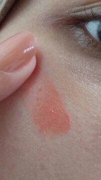 Apply blush on cheeks. Natural makeup application on an Asian woman face,
