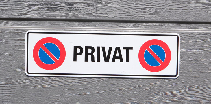 Schild Privat an einem Garagentor, Parkieren vor der Garage ist verboten