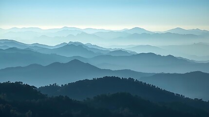 Fototapeta premium misty mountain range at dawn with layered fog and soft sunlight