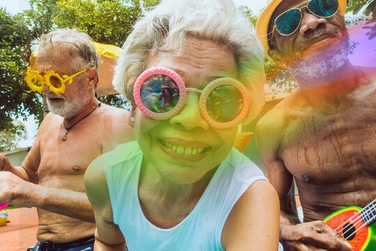 Closeup of diverse senior adults sitting by the pool enjoying summer together