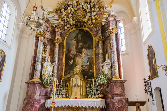 Interior of St. Andreas church in Etting with ornate baroque altar, pulpit and wooden pews
