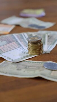 Vertical shot of stacked Indian coins on five hundred rupee notes