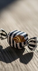Naklejka premium Candy wrapper with black and white stripes on wooden surface.
