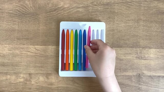 child hands putting seventh marker into case