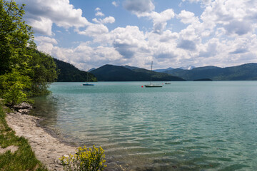 Obraz premium Panoramic view of turquoise Lake Walchensee and the Bavarian Alps under a cloudy sky