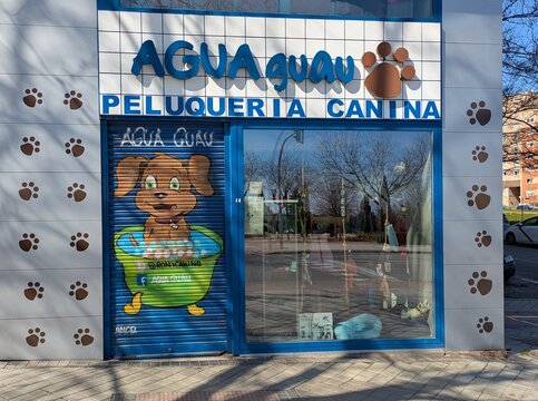 Dog grooming. Fachada de tienda para mascotas y peluquer&iacute;a canina, con dibujo de un perro ba&ntilde;&aacute;ndose en el cierre de la puerta, en Madrid, Espa&ntilde;a, 28 de febrero de 2026