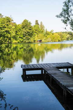 Wooden pier overlooking the calm water of Wesslinger See lake in Bavaria, Germany