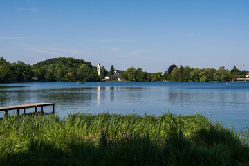 Fototapeta premium Wooden pier overlooking the calm water of Wesslinger See lake in Bavaria, Germany