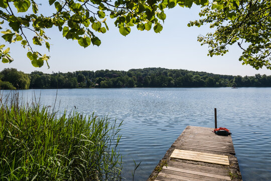 Wooden pier overlooking the calm water of Wesslinger See lake in Bavaria, Germany