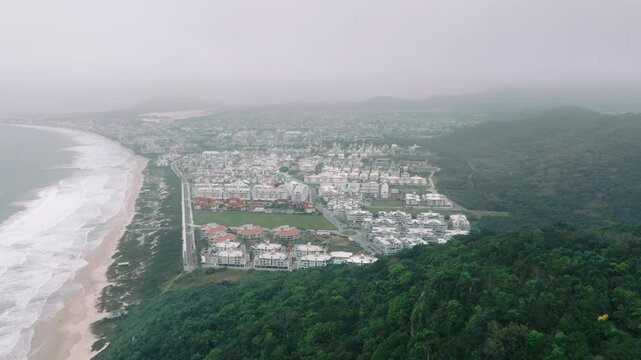 High aerial of Ingleses cityscape, beach and forested slope