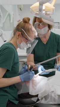 Dentist performs air abrasion procedure using specialized sandblasting nozzle. High pressure mixture of water and bicarbonate powder effectively removes dental plaque and stubborn stains