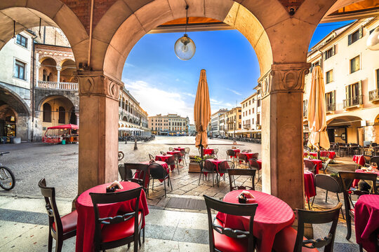 Padova, Italy. Piazza della frutta historic square and cafe arches view