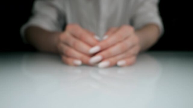Female hands gathering white capsules on table concept of medication intake dosage healthcare treatment and pharmaceutical use.
