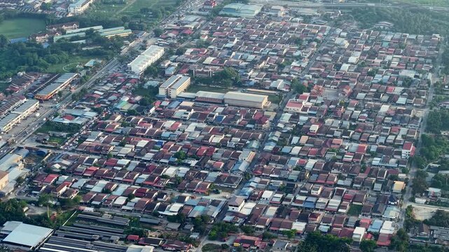 Drone view captures kampung baru Valdor village with evening lights glowing across rooftops and pathways.