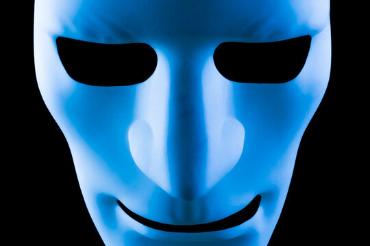 Artificial intelligence robot mask or face staring at the camera. Blue robotic android taking over the workplace concept