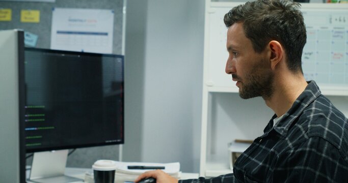 Cybersecurity Analyst Monitoring Encryption.Caucasian man, a cybersecurity analyst, monitors encryption & network security in office. Focused on digital defense, coding, and system support.

